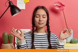 Mahasiswa duduk sendiri, mencoba menenangkan pikiran dengan tetap positif saat suasana hati sedang sedih.